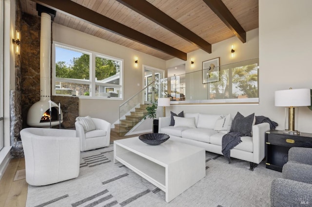 living area with wood finished floors, stairway, wood ceiling, beamed ceiling, and a wood stove