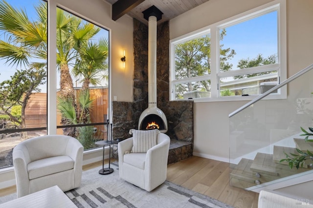sunroom with a wood stove and beamed ceiling