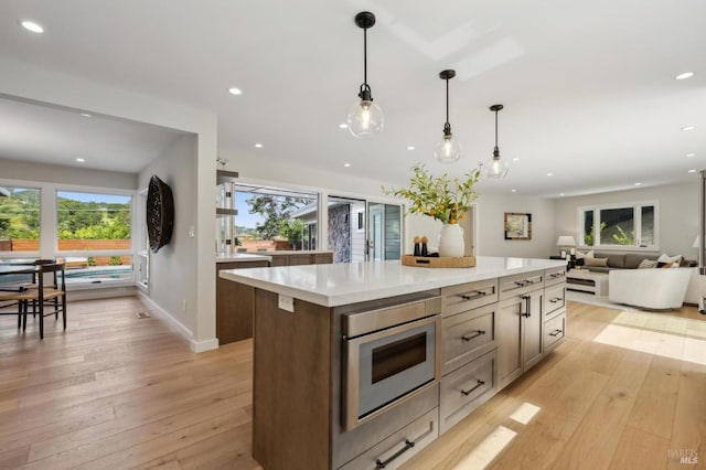kitchen featuring recessed lighting, light wood-style floors, a center island, and light countertops