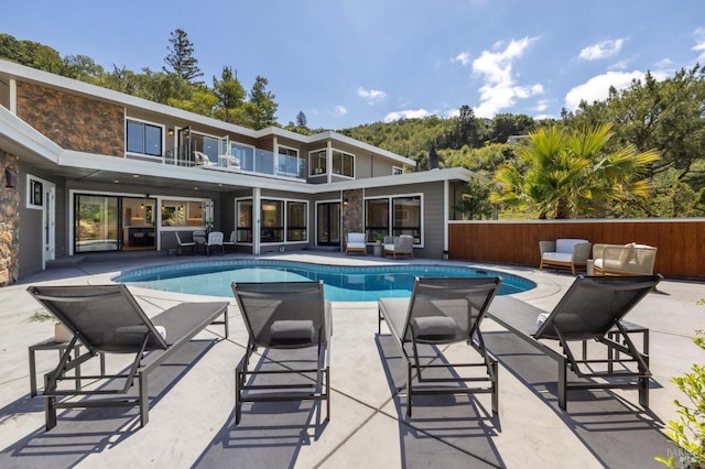 view of swimming pool featuring a patio, a fenced in pool, an outdoor hangout area, and fence