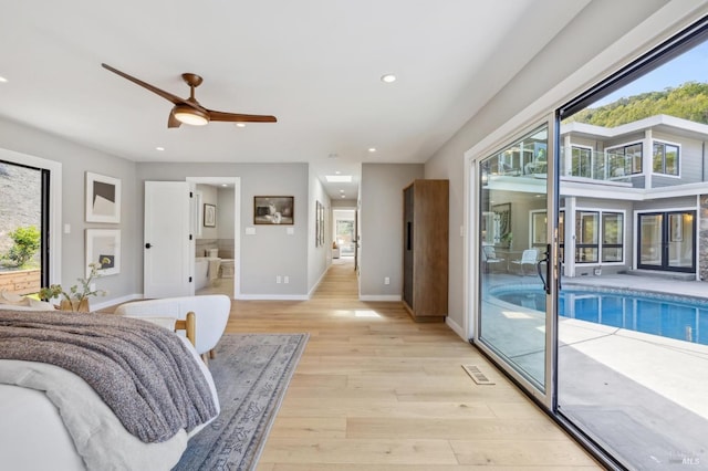 bedroom with light wood-style floors, recessed lighting, access to outside, and multiple windows