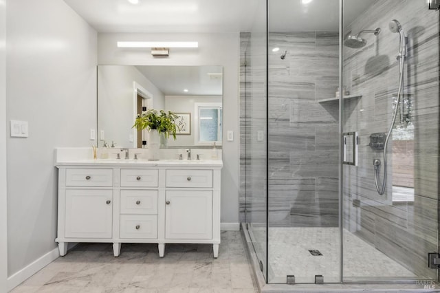 bathroom featuring double vanity, a shower stall, and baseboards