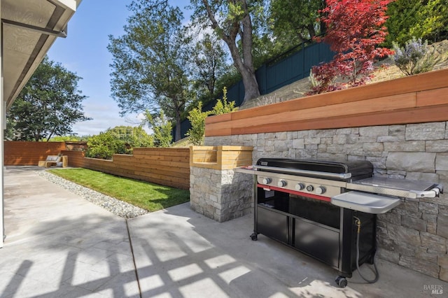 view of patio featuring grilling area, exterior kitchen, and fence