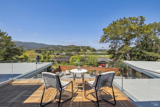 deck featuring a mountain view and outdoor dining area