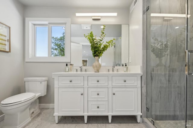 full bathroom with a stall shower, toilet, double vanity, and a sink