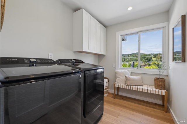 laundry room with independent washer and dryer, light wood-style flooring, baseboards, recessed lighting, and cabinet space