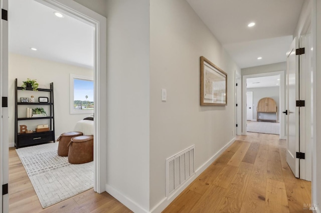 corridor featuring recessed lighting, visible vents, baseboards, and light wood-type flooring