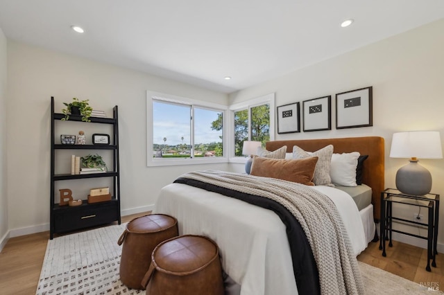 bedroom with baseboards, recessed lighting, and light wood-style flooring