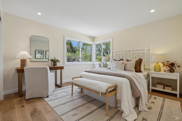 bedroom with wood finished floors, recessed lighting, and baseboards