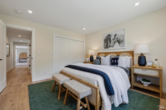 bedroom with light wood finished floors, a closet, and recessed lighting
