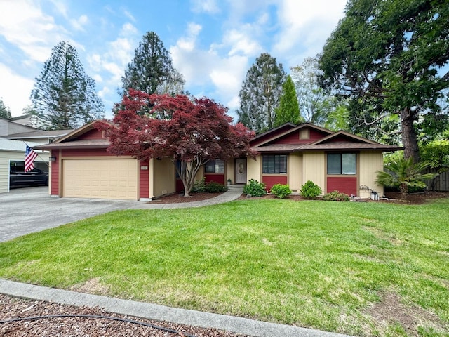 single story home featuring an attached garage, a front lawn, and aphalt driveway