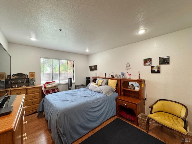 bedroom featuring wood finished floors, a textured ceiling, and recessed lighting