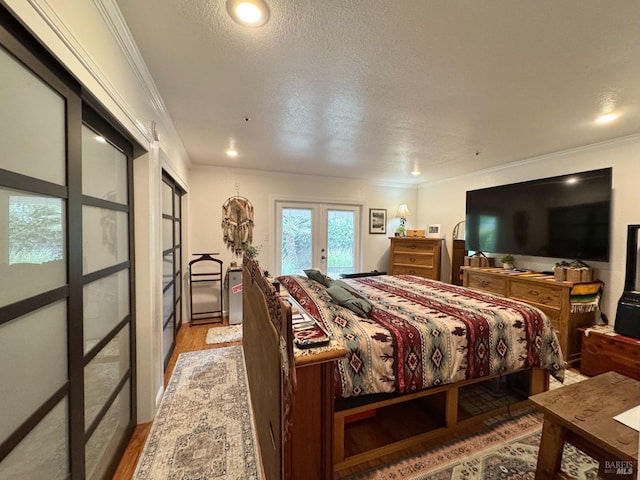 bedroom featuring access to exterior, french doors, light wood-type flooring, crown molding, and a textured ceiling