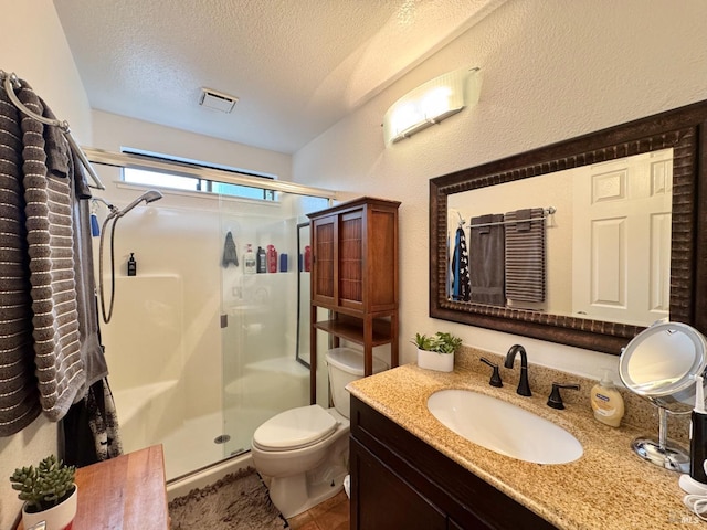 full bathroom with visible vents, toilet, vanity, a textured ceiling, and a stall shower