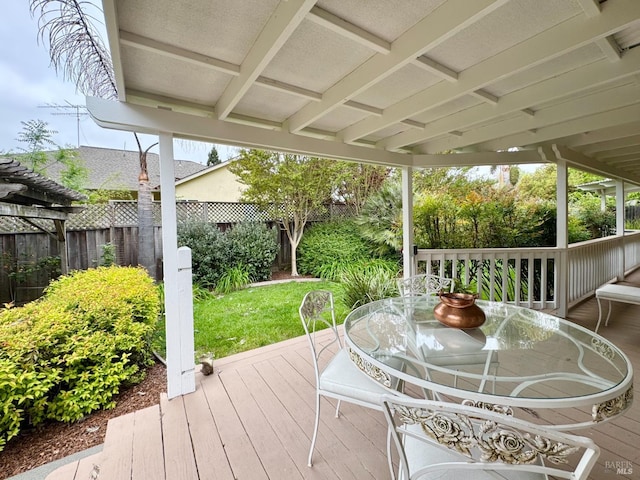 wooden deck with a fenced backyard and outdoor dining space