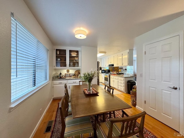 dining space featuring visible vents, a wealth of natural light, and light wood-style floors