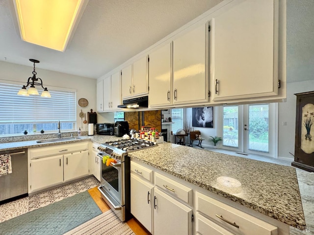 kitchen featuring light stone counters, under cabinet range hood, stainless steel appliances, a sink, and pendant lighting