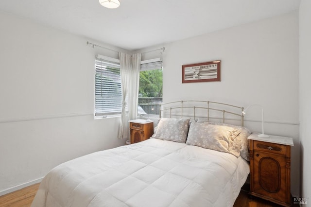 bedroom with baseboards and wood finished floors