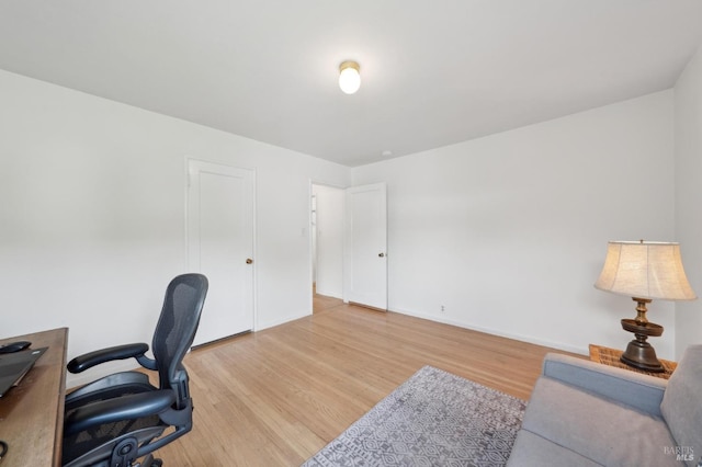 office area with baseboards and light wood finished floors