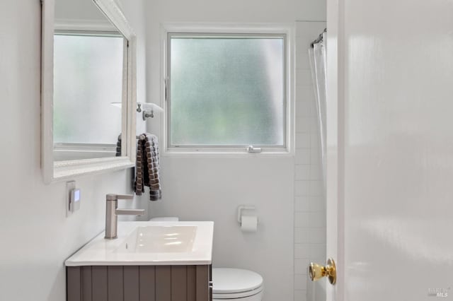 bathroom featuring plenty of natural light, toilet, and vanity