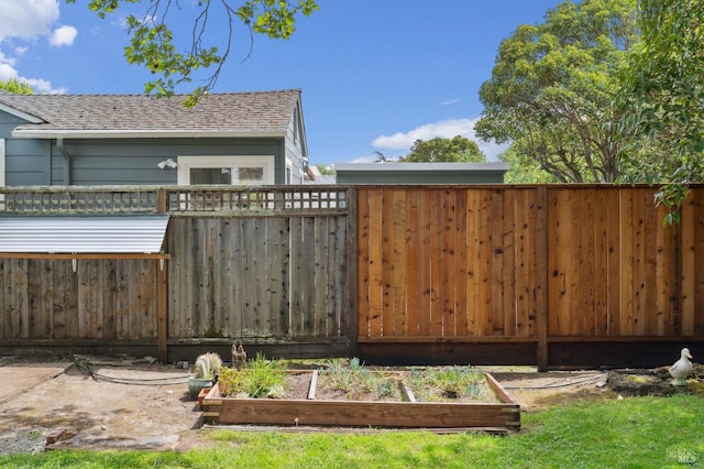 view of yard featuring fence and a vegetable garden