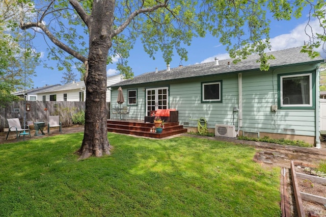 rear view of house featuring a yard, fence, a deck, and a shingled roof