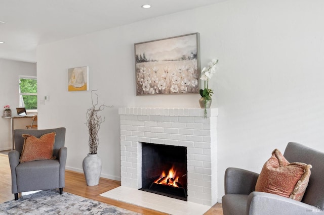 sitting room with a fireplace, wood finished floors, baseboards, and recessed lighting