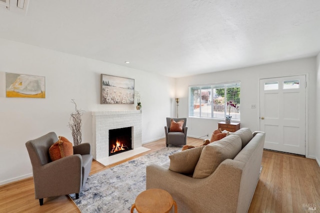 living room featuring a fireplace, wood finished floors, and baseboards