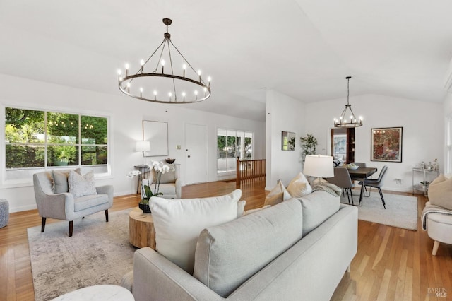 living room with a chandelier, wood finished floors, lofted ceiling, and baseboards