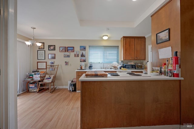 215 Iowa St, Santa Rosa, CA 95401 - kitchen featuring brown cabinets, light countertops, stainless steel microwave, a peninsula, and light wood-style flooring