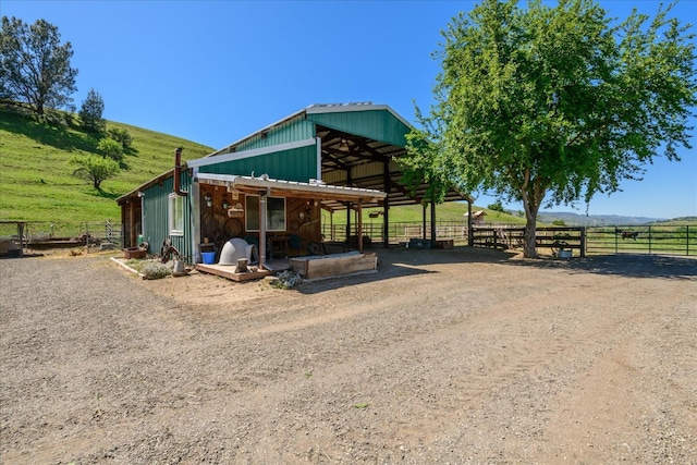 exterior space featuring an exterior structure, an outbuilding, a rural view, and board and batten siding