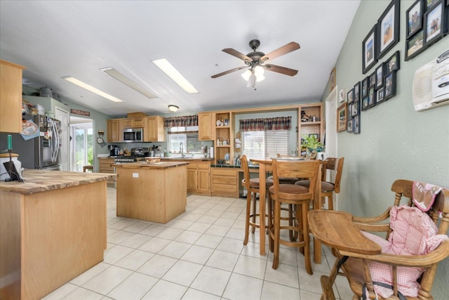 kitchen featuring butcher block countertops, a center island, open shelves, and stainless steel appliances