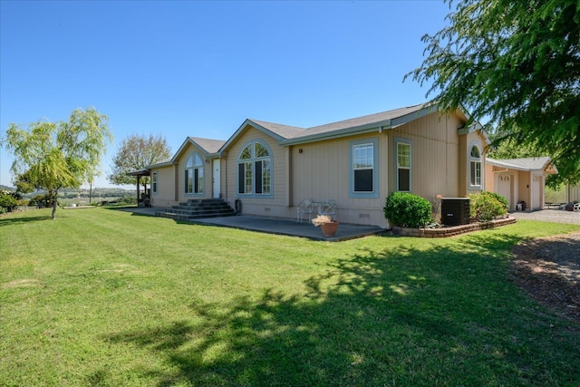 rear view of property with central AC, crawl space, a lawn, a patio, and a garage