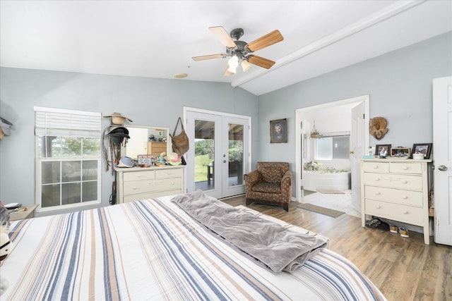 bedroom with wood finished floors, ensuite bathroom, french doors, lofted ceiling, and access to exterior
