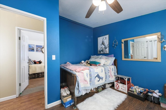 bedroom with baseboards, a ceiling fan, and wood finished floors