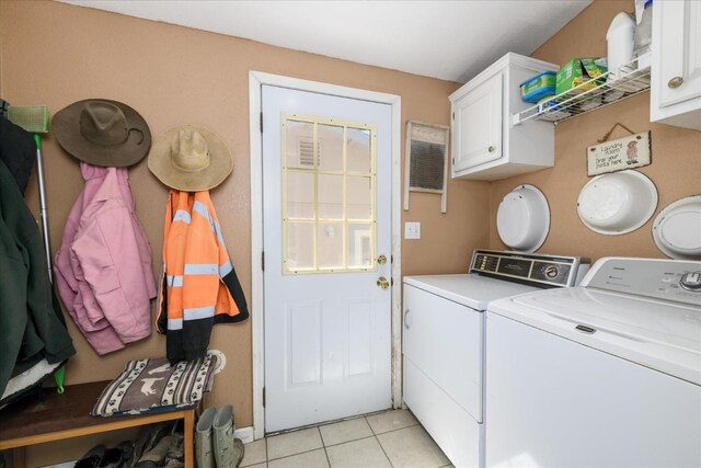 washroom with washing machine and dryer, cabinet space, and light tile patterned floors