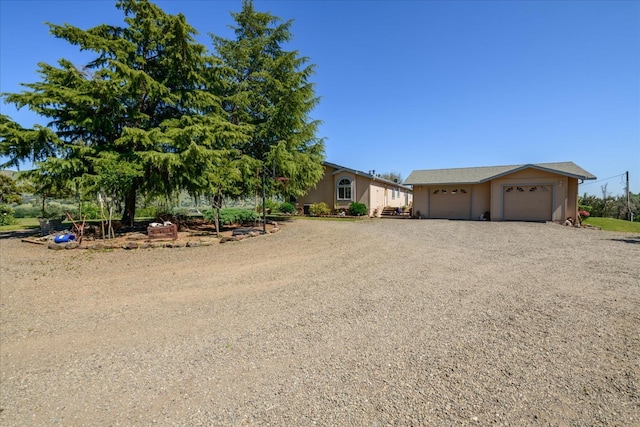 ranch-style house with stucco siding, driveway, and a garage