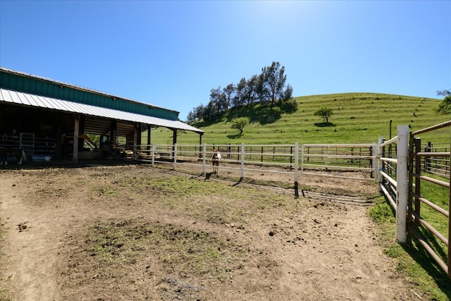 view of yard with an exterior structure, a rural view, and an outbuilding