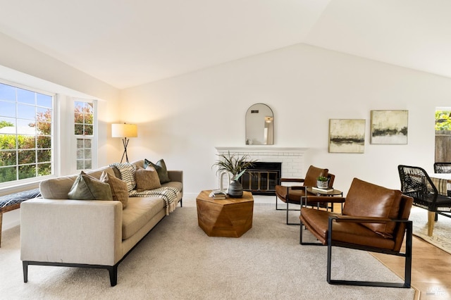 living room featuring vaulted ceiling, wood finished floors, and a fireplace