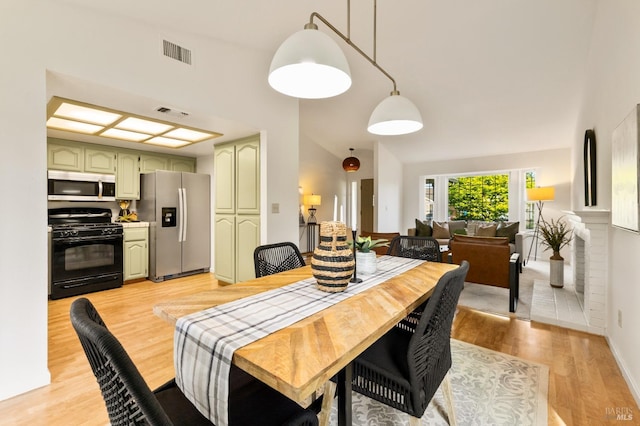 dining room with baseboards, visible vents, and light wood-type flooring