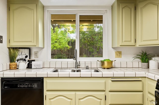 kitchen with dishwasher, a sink, and cream cabinetry
