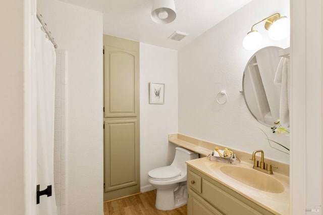 full bath with wood finished floors, vanity, a shower with curtain, toilet, and visible vents