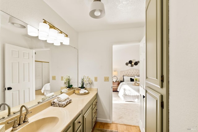 bathroom with wood finished floors, vanity, and ensuite bathroom