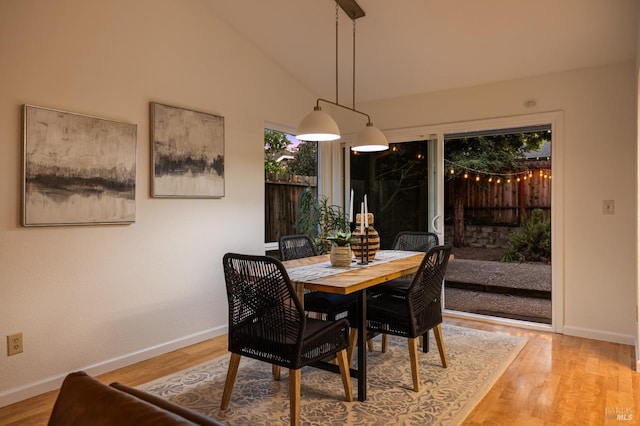 dining room featuring baseboards, light wood-style floors, and a wealth of natural light