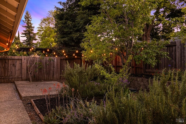 yard at dusk with a fenced backyard