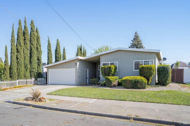 single story home featuring driveway, fence, an attached garage, a front yard, and stucco siding