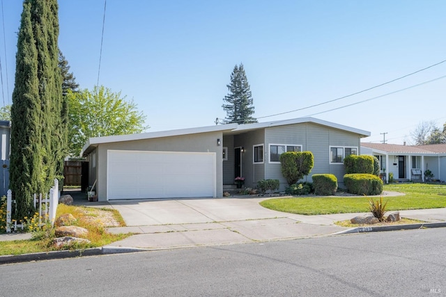 ranch-style home with concrete driveway, a front yard, and a garage