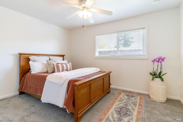 bedroom featuring light colored carpet, baseboards, and a ceiling fan