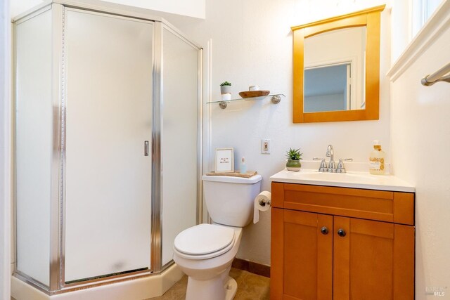 full bathroom with vanity, a shower stall, and toilet