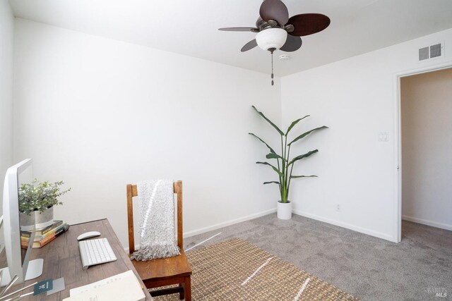 carpeted office space with ceiling fan, baseboards, and visible vents